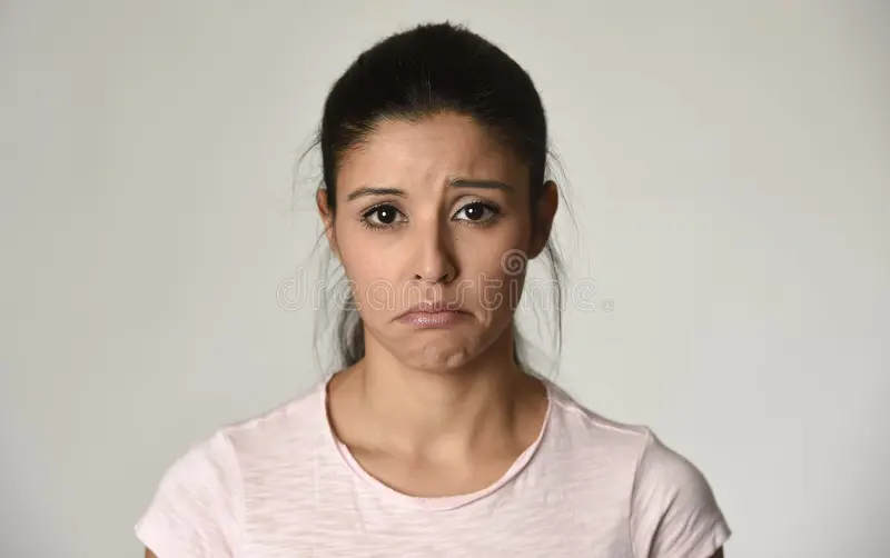 Woman wearing white sweater with worried look on her face.